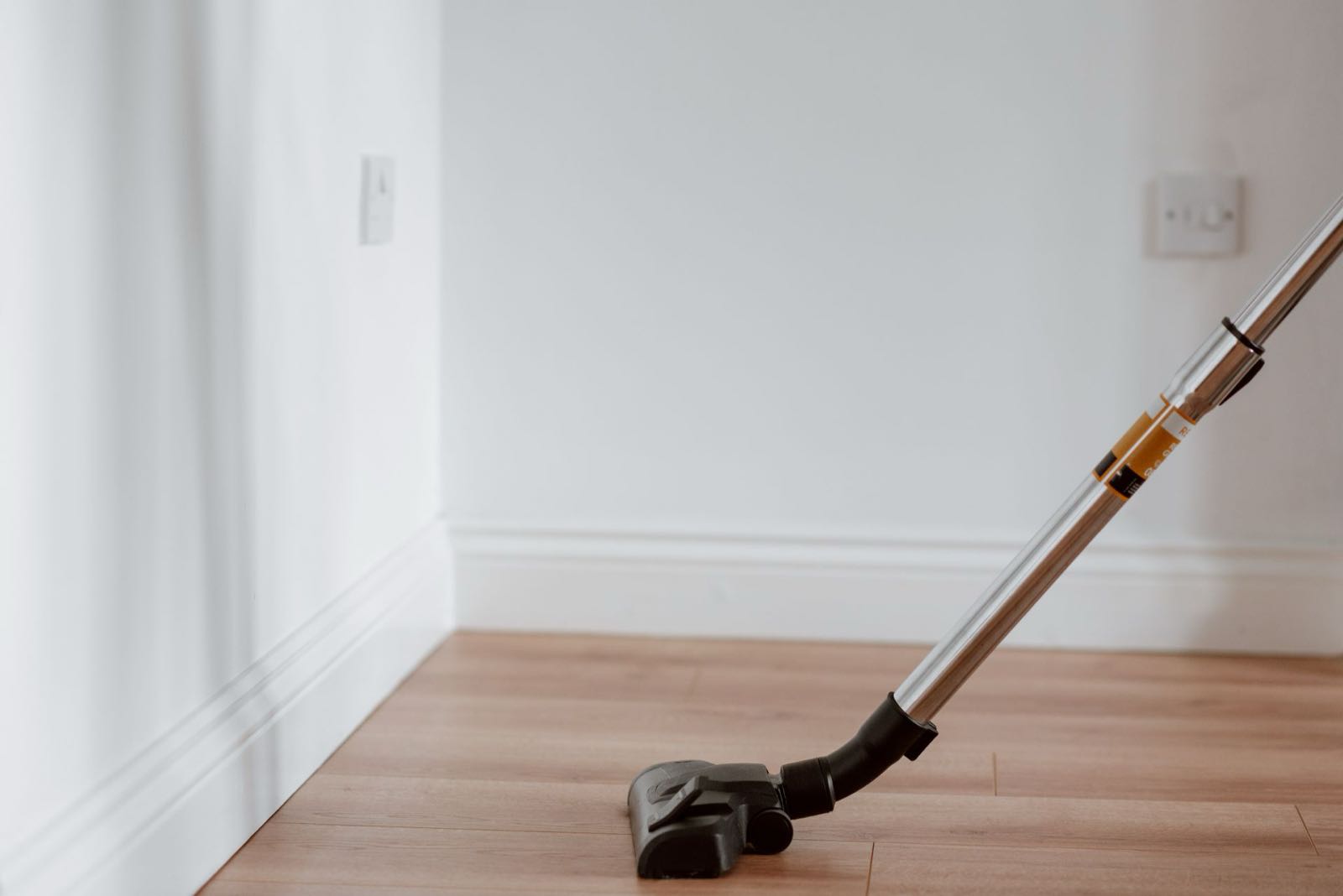 Limpieza de fin de obra con aspiradora sobre suelo de madera en Barcelona